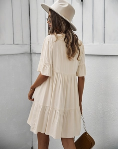 Vue arrière d'une robe courte à volants beige avec col en V et manches volantées