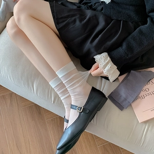 White vertical stripe sheer crew socks styled with black Mary Jane shoes for women