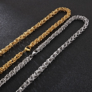 Detail of gold and silver Byzantine weave stainless steel chains on black background