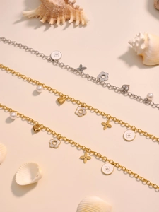 Detail von geschichteten Gold- und Silberketten mit Zirkonherzen und Emaille-Anhängern