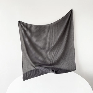 Artistic hanging display of dark gray pleated square scarf with soft fabric texture