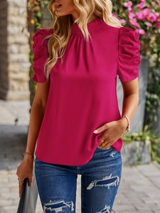 Detail of elegant fuchsia satin blouse featuring puff sleeves and a classic round neck