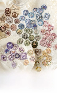 Close-up of vintage Time Mail Series embossed stickers with wax seal floral patterns