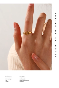 Detail eines goldenen Schweinenasenrings am Finger mit Ankerkettendesign