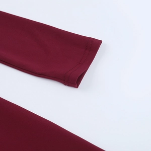 Détail des poignets à manches longues avec double couture en tissu bordeaux foncé fini