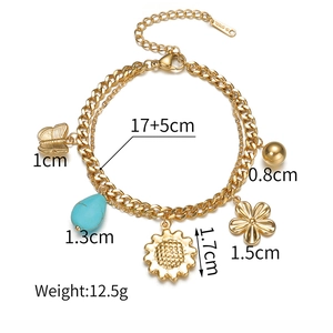 Détail du bracelet en acier inoxydable plaqué or 18K avec breloques fleurs et papillon
