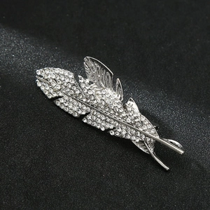 Macro shot of silver feather brooch with crystal rhinestones on a black background