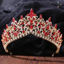 Detail of baroque gold crown featuring intricate red crystals and sparkling rhinestones