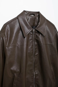 Detalle de una chaqueta de cuero sintético marrón oscuro con cuello de solapa y cremallera