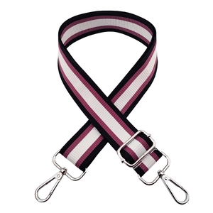 Dettaglio tracolla a righe nero bianco e bordeaux con fibbie in metallo argentato