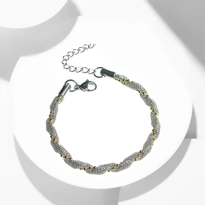Detail of woven mesh titanium steel bracelet with gold beads and lobster clasp closure