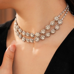 Close-up of double-layer necklace with diamond flower pendants on model neck
