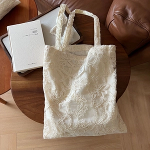 Detail of French vintage lace tote bag featuring intricate floral embroidery and double handles