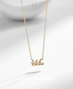 Macro detail of gold 444 numeral pendant necklace with sparkling zircon accent