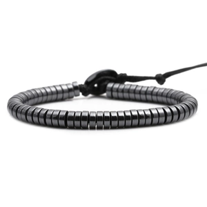 Polished black hematite cylindrical bead bracelet with adjustable nylon cord on white background