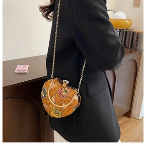 Close-up of heart evening bag with gold sequins, 3D floral embroidery, and chain strap