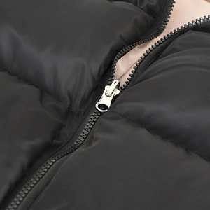 Close-up of black puffer vest zipper detail showing polyester fabric and metal slider