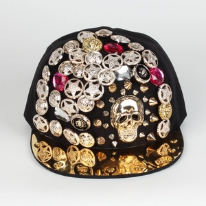 Detail of a punk snapback hat with golden skull, metallic studs and faux rubies