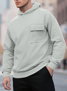 Detail of light grey fleece hoodie featuring a front utility pocket and ribbed knit cuffs