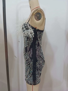 Détail de paillettes ondulées et plumes sur cette robe de soirée dos nu