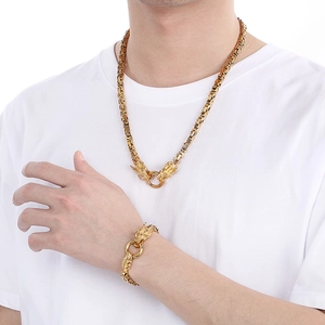 Detailed close-up of golden dragon-headed woven chain necklace and bracelet on model