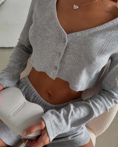 Detailed view of grey knit cardigan and shorts showing delicate hollow-out texture