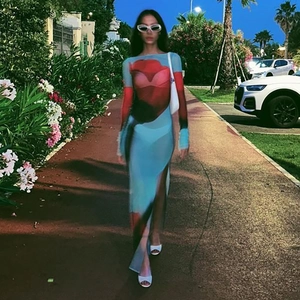 Gros plan sur la robe en maille semi-transparente avec imprimé rouge et bleu et fente