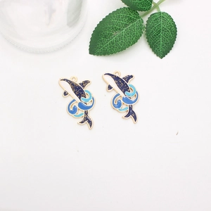 Detailed close-up of blue whale alloy charms with gold edges and glitter enamel finish