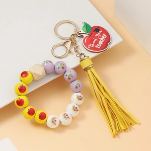Close-up of teacher appreciation keychain with colorful beads and apple pendant