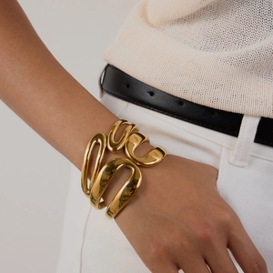 Detailed view of wide 18K gold-plated stainless steel cuff with sculptural layered design
