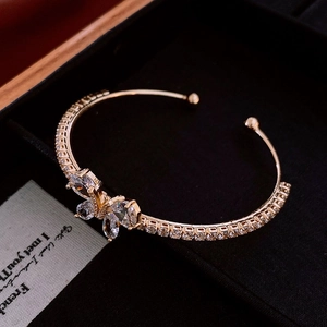 Détail d'un bracelet papillon doré serti de zircons posé sur une carte cadeau