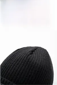 Close-up of black winter knit hat with thick ribbed texture for cold protection