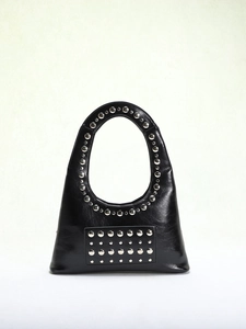 Detailed view of silver rivets on black leather punk style underarm bag with U-shaped design