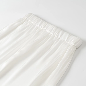 Gros plan détaillé du pantalon en satin blanc avec une taille élastique de haute qualité