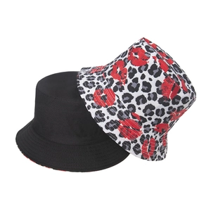 Detail of reversible bucket hat showing leopard print, red lip pattern and solid black fabric