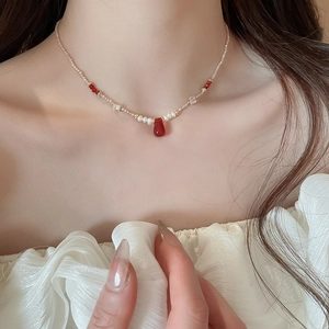 Detail of red teardrop gemstone pendant on a freshwater pearl and crystal necklace