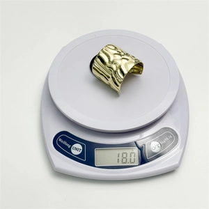 Irregular hammered gold hair cuff tie on scale showing a 18.0g premium metal weight