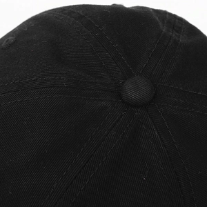 Detailed close-up of the black twill cotton baseball cap texture and stitched top button