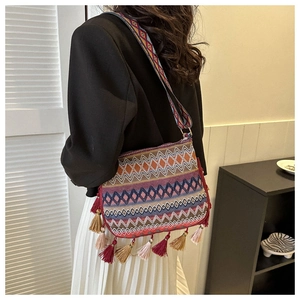 Detailed view of bohemian crossbody bag featuring colorful woven patterns and tassel accents