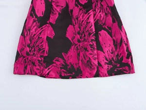 Detail of black jacquard fabric with pink floral patterns on an elegant A-line mini dress
