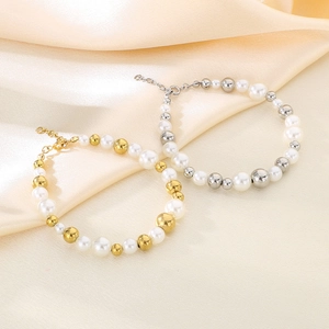 Détails de bracelets en perles dorées et argentées sur un fond de tissu en soie champagne