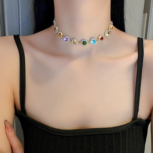 Colorful gemstone necklace with gold round diamond-encrusted links on neck