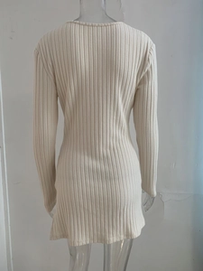 Close-up of the beige ribbed knit texture and back stitching of the slim-fit dress
