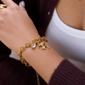 18K vergoldetes Edelstahl-Vogelarmband mit Tigerauge und Kristallen am Handgelenk getragen