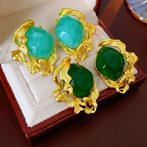 Close-up of vintage emerald earrings in gold organic settings within a jewelry box