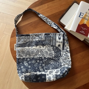 Detail of bohemian blue and white floral pattern on a retro linen crossbody bag