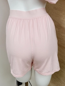 Detail view of pink knitted cotton lounge shorts with a wide elastic waistband for comfort