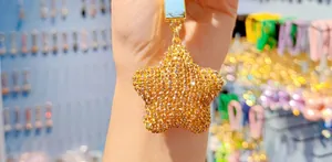 Close-up of golden star keychain featuring full rhinestones and matching crystal strap