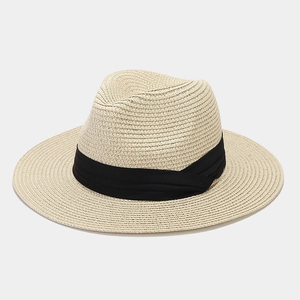 Macro view of woven straw texture and black band detail on a beige Panama sun hat