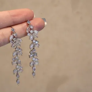 Detail view of long silver tassel earrings with sparkling rhinestones and marquise cut gems